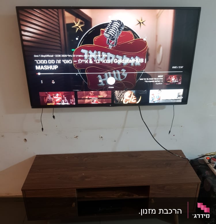 טלוויזיה תלויה על הקיר עם כבלים חשופים